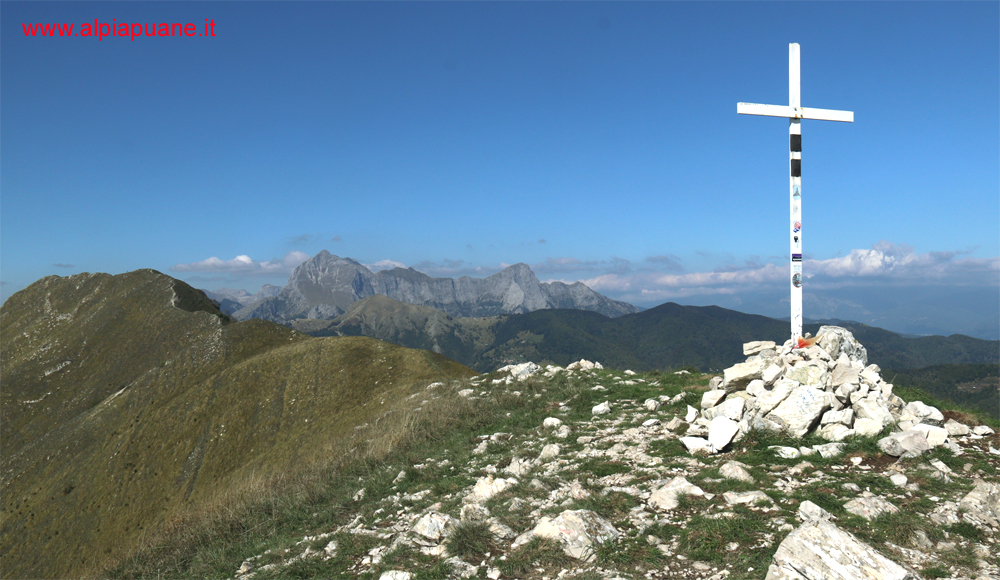 La croce sulla cima sud-est del monte Piglione, sullo sfondo il monte Croce e il Gruppo delle Panie